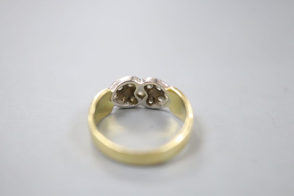 A modern 750 and eleven stone diamond set twin hearts dress ring, size N, gross 5.1 grams.